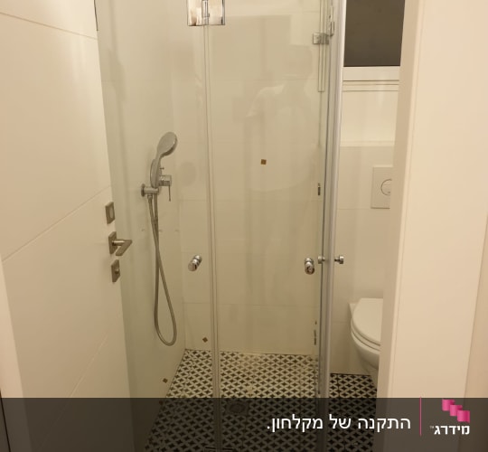 מקלחון זכוכית מתקפל מותקן בחדר רחצה מעוצב